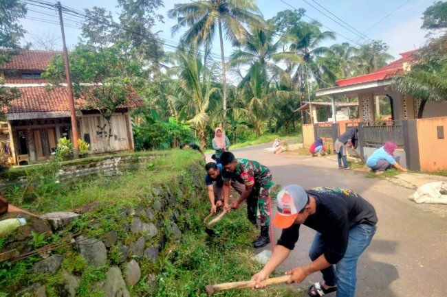 Guna Menjaga Kebersihan Lingkungan, Babinsa Bersama Warga Melaksanakan Kerja Bakti Pembersihan Parit Jalan 