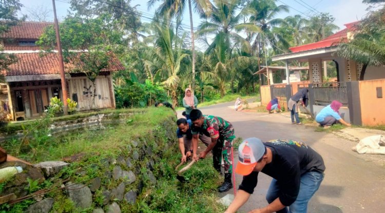 Guna Menjaga Kebersihan Lingkungan, Babinsa Bersama Warga Melaksanakan Kerja Bakti Pembersihan Parit Jalan 